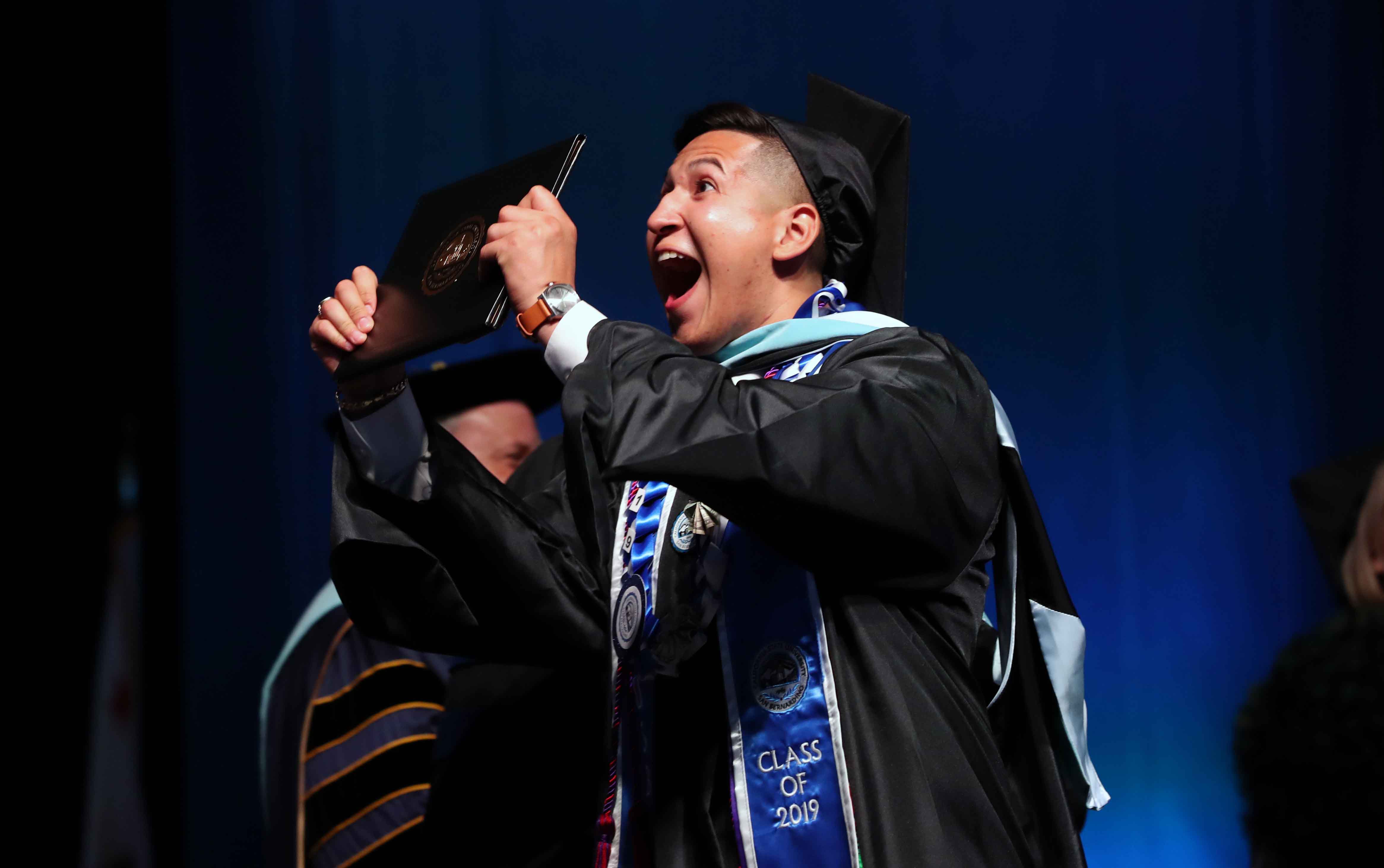 A student celebrates at one of four CSUSB commencement ceremonies at Toyota Arena