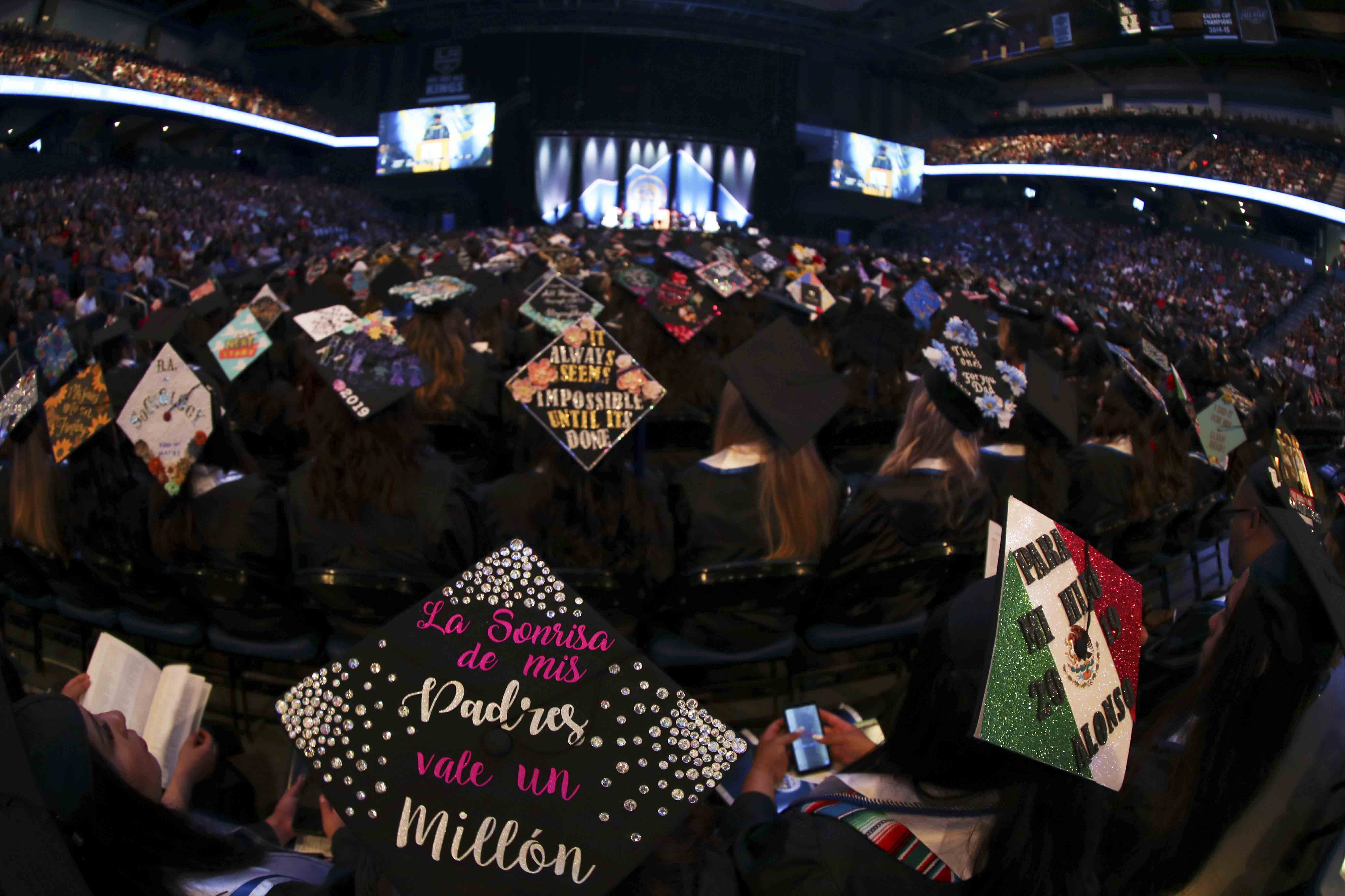 Decorated mortar boards at a CSUSB commencement ceremony at Toyota Arena