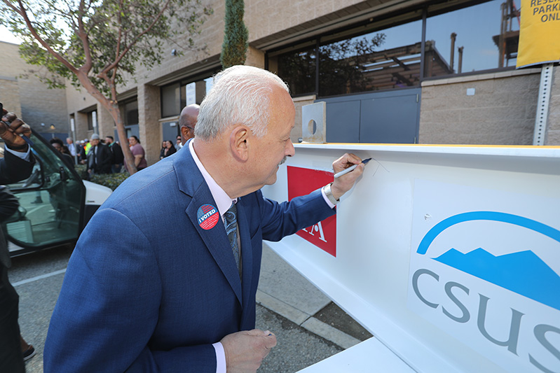 SMSU Topping Out ceremony, President Morales signs the beam