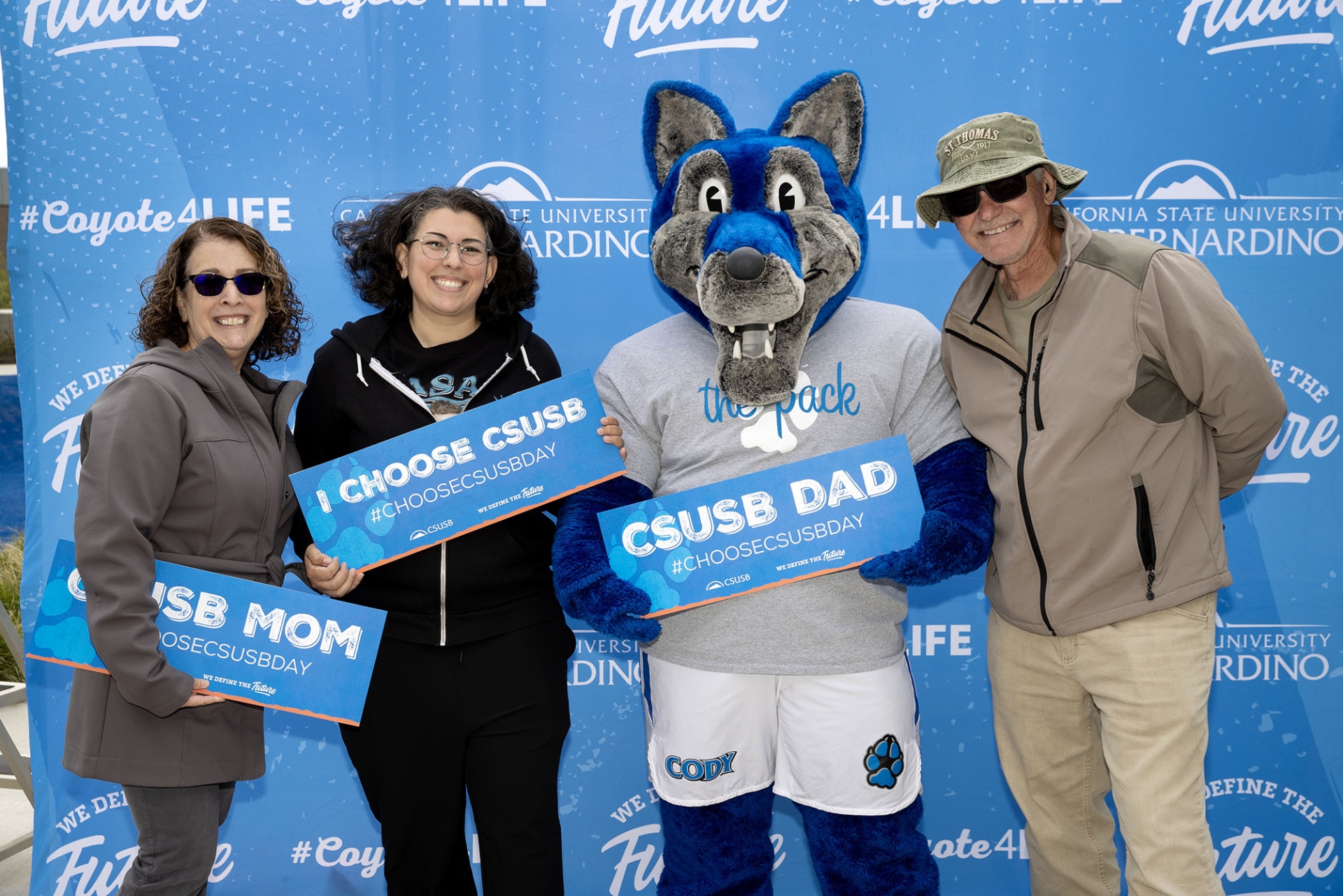 A family poses with Cody Coyote on Choose CSUSB Day.